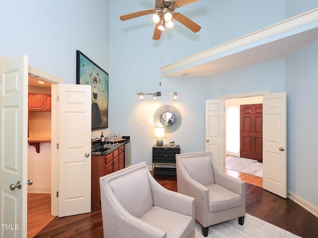 sitting room featuring dark hardwood / wood-style flooring, ceiling fan, and sink