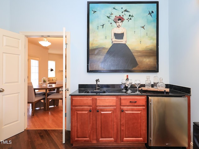 bar featuring refrigerator, dark hardwood / wood-style flooring, and sink