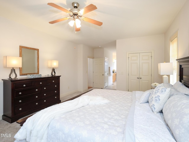 bedroom featuring ceiling fan, a closet, and light colored carpet