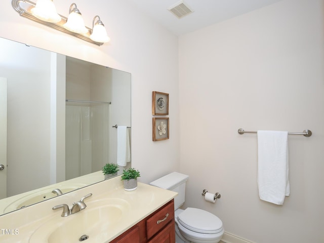 bathroom featuring a shower, vanity, and toilet