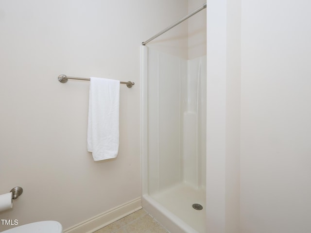 bathroom featuring toilet, tile patterned flooring, and walk in shower