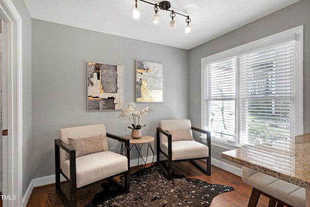 living area featuring visible vents, baseboards, and wood finished floors