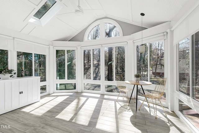 sunroom / solarium with vaulted ceiling with skylight