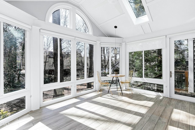 unfurnished sunroom with lofted ceiling with skylight