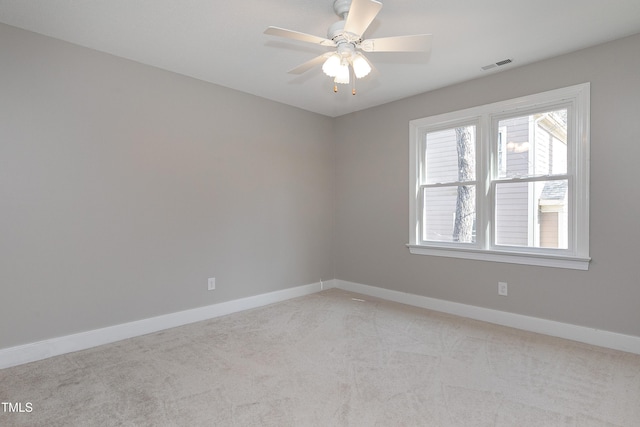 unfurnished room featuring a ceiling fan, visible vents, light carpet, and baseboards