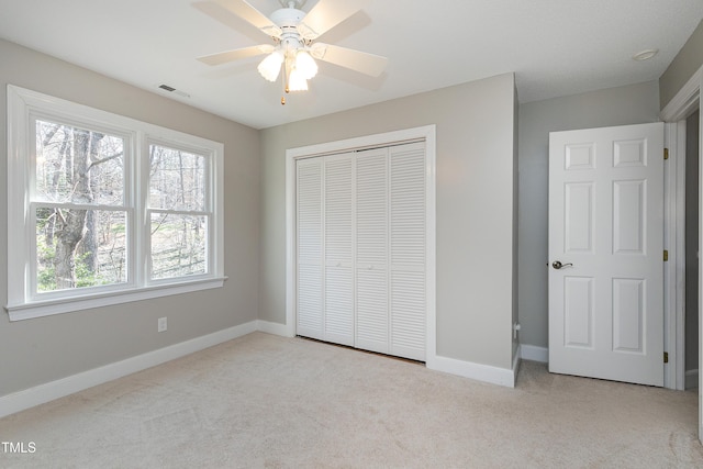 unfurnished bedroom with light carpet, baseboards, visible vents, and a closet