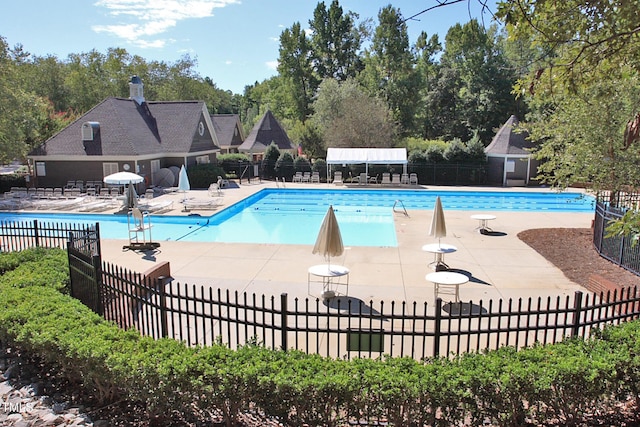 community pool with fence and a patio