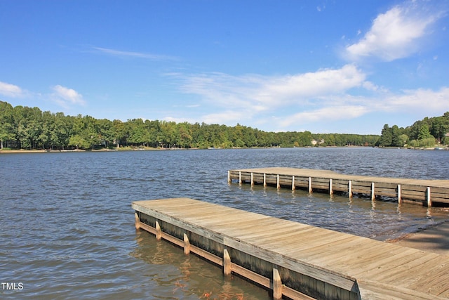 dock area featuring a water view and a wooded view