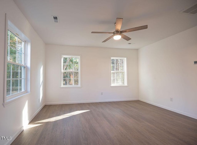 unfurnished room with dark hardwood / wood-style floors, ceiling fan, and a wealth of natural light