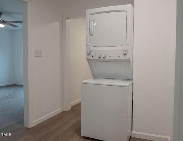 laundry area featuring ceiling fan, stacked washer and dryer, and dark wood-type flooring