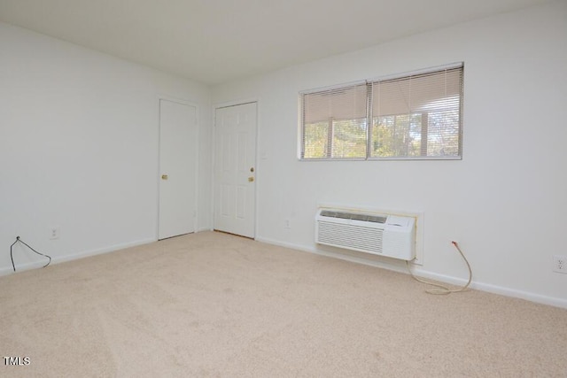 empty room with an AC wall unit and light carpet