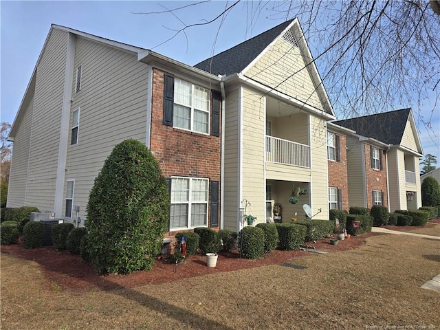 view of side of home featuring a yard and a balcony