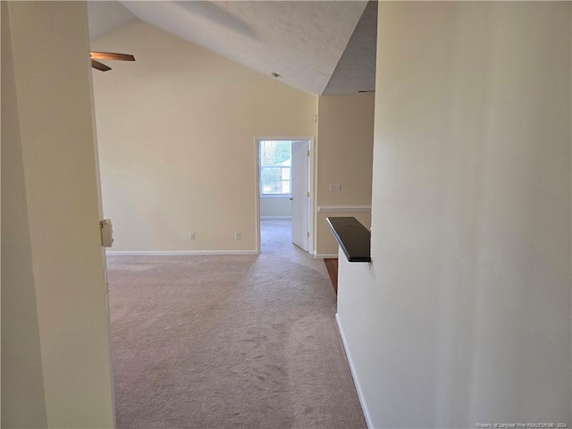 hall featuring light carpet and high vaulted ceiling