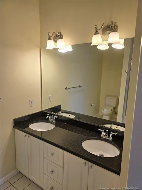 bathroom with tile patterned flooring, vanity, and toilet