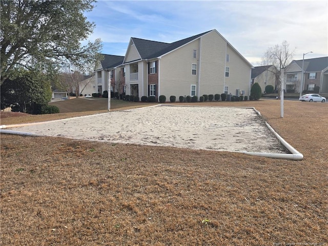 view of home's community with volleyball court and a lawn