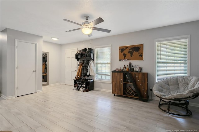 exercise room featuring ceiling fan and light hardwood / wood-style flooring