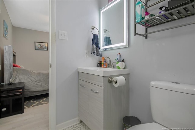 bathroom featuring wood-type flooring, vanity, and toilet