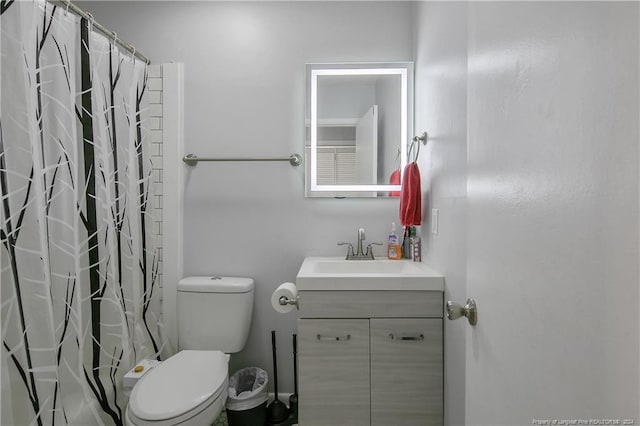 bathroom featuring vanity, toilet, and curtained shower