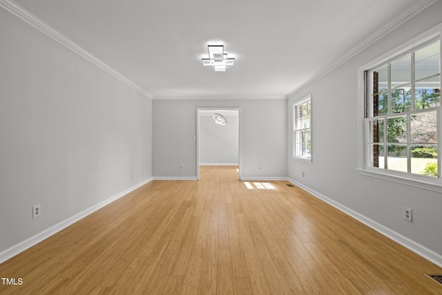 unfurnished room with ornamental molding, light wood-style flooring, and baseboards