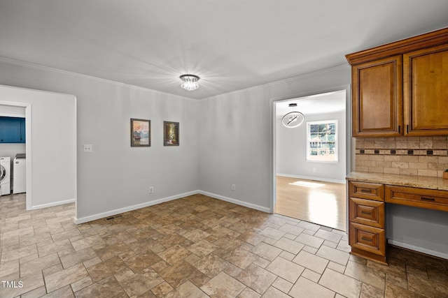 unfurnished dining area with washing machine and dryer, visible vents, baseboards, stone finish floor, and crown molding