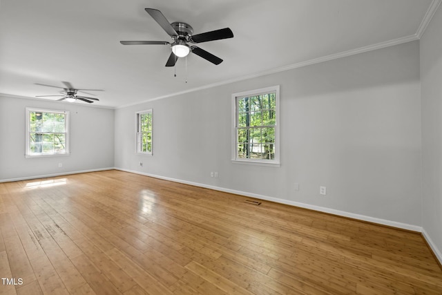 empty room with ceiling fan, visible vents, baseboards, ornamental molding, and light wood-type flooring