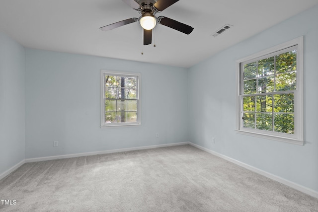 empty room with carpet, visible vents, plenty of natural light, and baseboards