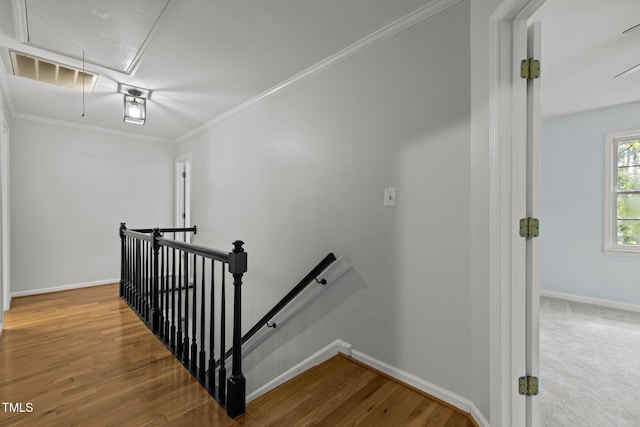 stairway with attic access, ornamental molding, baseboards, and wood finished floors