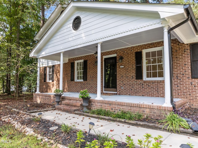 view of front of home featuring a porch and brick siding