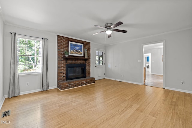 unfurnished living room featuring a brick fireplace, plenty of natural light, visible vents, and light wood finished floors