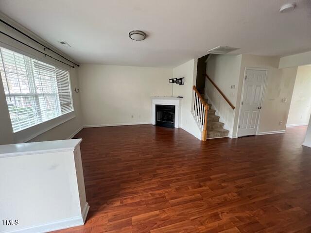 unfurnished living room featuring dark hardwood / wood-style flooring