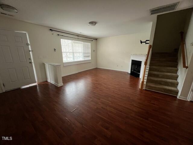 unfurnished living room featuring dark wood-type flooring