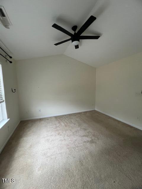 carpeted spare room featuring ceiling fan and lofted ceiling