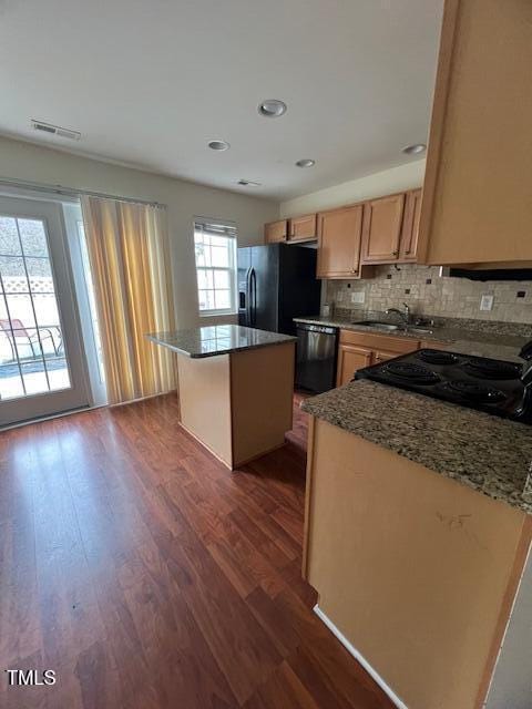 kitchen featuring backsplash, dark wood-type flooring, sink, black appliances, and a center island