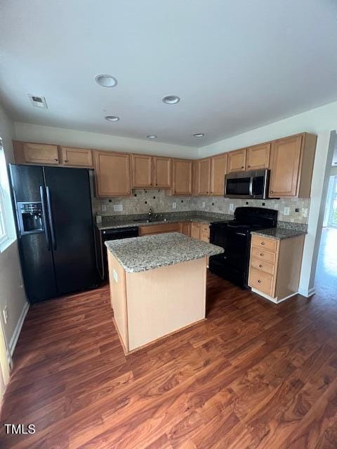 kitchen featuring a center island, black appliances, light stone countertops, tasteful backsplash, and dark hardwood / wood-style flooring