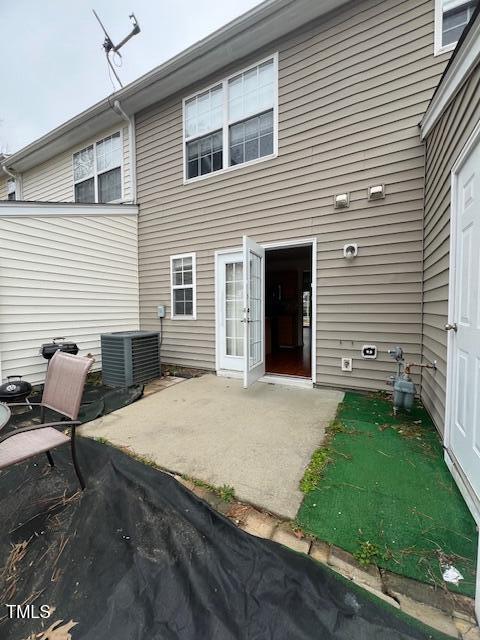 rear view of house with cooling unit and a patio