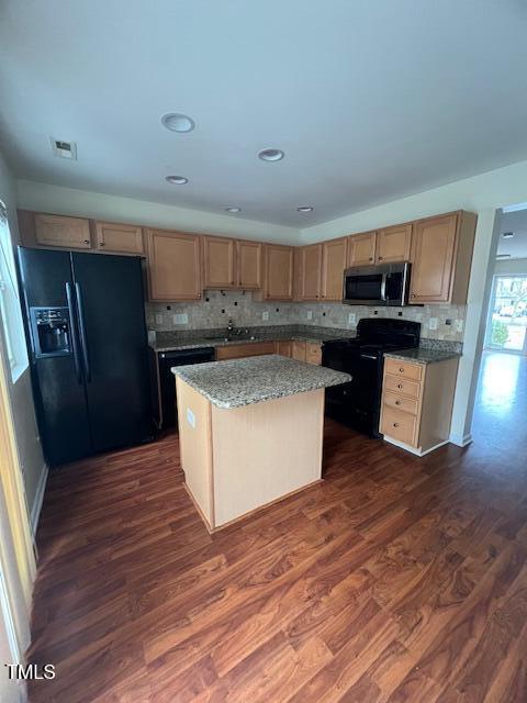 kitchen featuring light stone countertops, dark wood-type flooring, backsplash, a kitchen island, and black appliances