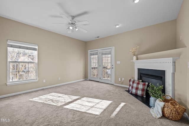 living room with light carpet, plenty of natural light, and ceiling fan