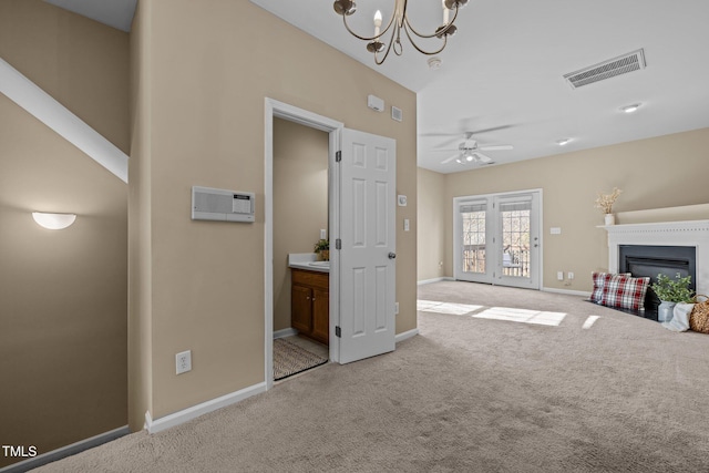 unfurnished living room with light carpet and ceiling fan with notable chandelier