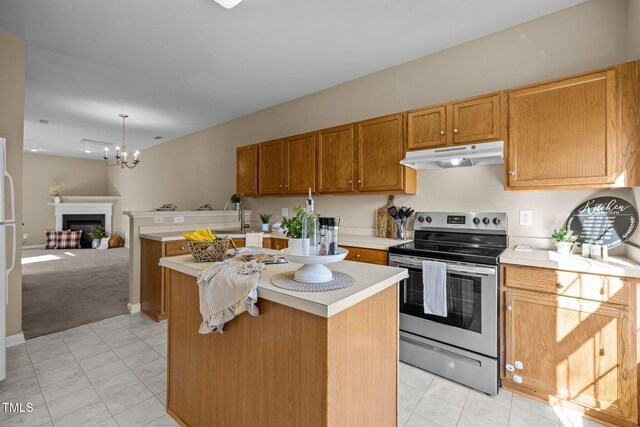 kitchen with stainless steel range with electric stovetop, white fridge, a kitchen island, and an inviting chandelier