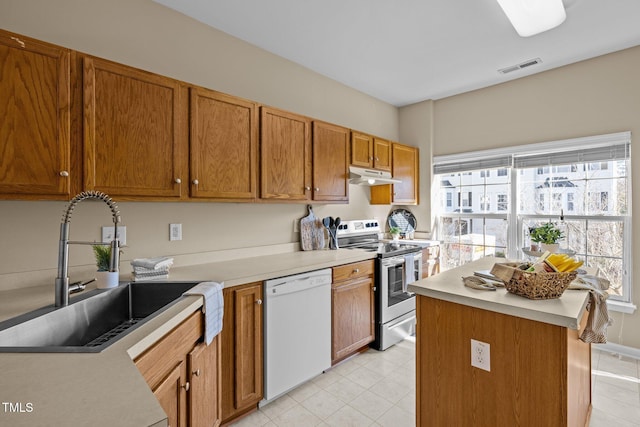 kitchen featuring stainless steel range with electric stovetop, dishwasher, a kitchen island, and sink