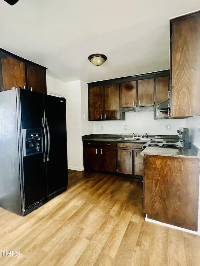 kitchen featuring stove, light wood-type flooring, black refrigerator with ice dispenser, dark brown cabinets, and sink