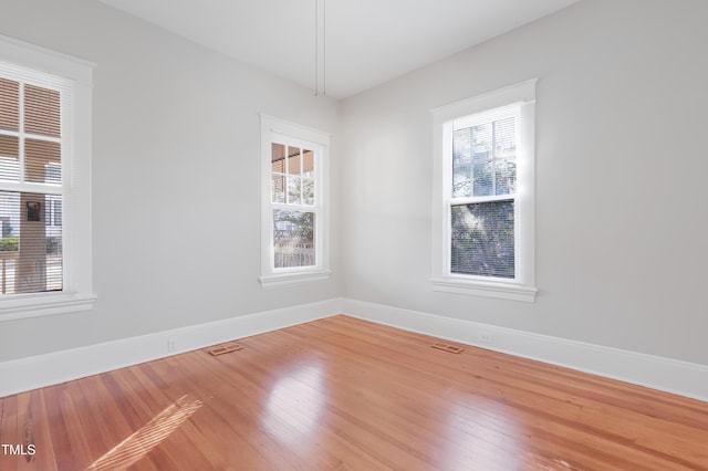 unfurnished room featuring hardwood / wood-style floors and a healthy amount of sunlight