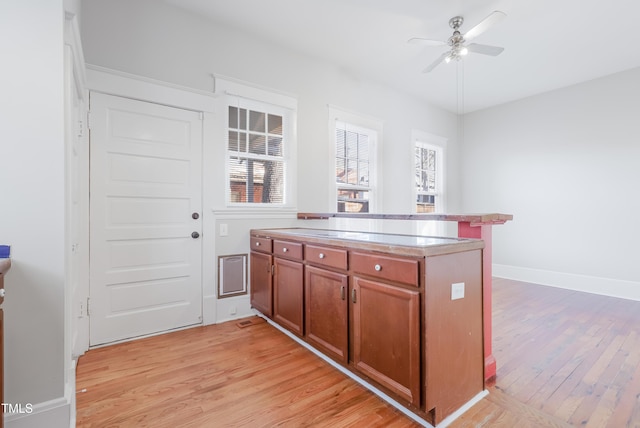 kitchen featuring ceiling fan and light hardwood / wood-style flooring