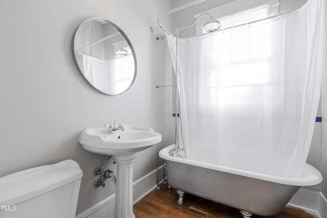 bathroom featuring hardwood / wood-style floors, shower / bath combination with curtain, and toilet