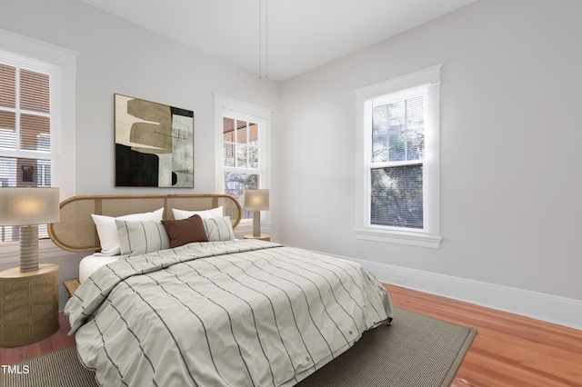 bedroom featuring wood-type flooring and multiple windows