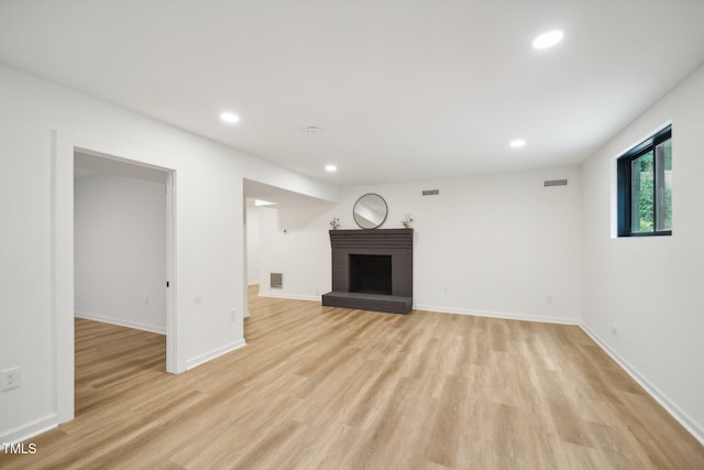 unfurnished living room featuring light hardwood / wood-style flooring and a fireplace