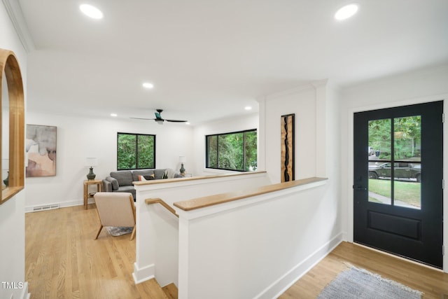 entryway featuring ceiling fan, crown molding, and light hardwood / wood-style floors