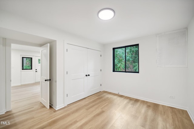 unfurnished bedroom featuring a closet and light hardwood / wood-style floors