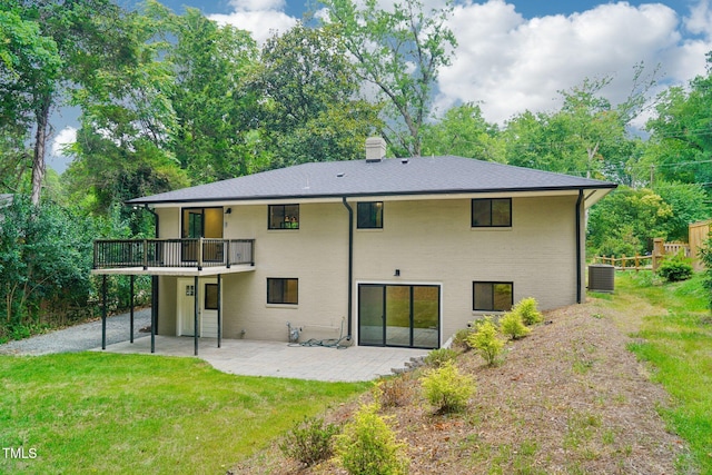 rear view of house with a wooden deck, cooling unit, a yard, and a patio