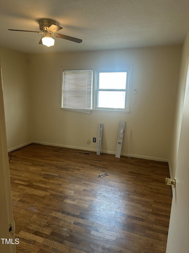 unfurnished room featuring a textured ceiling, ceiling fan, and dark hardwood / wood-style floors